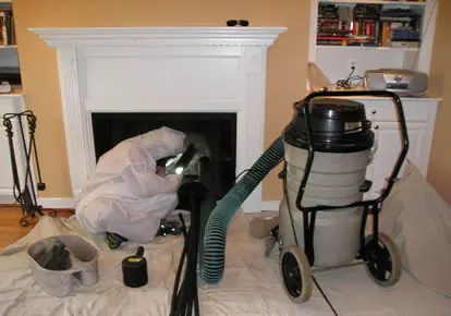 Professional chimney sweep performing inspection and cleaning