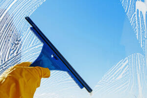 Squeegee using Eco-Friendly Cleaning Products on Window