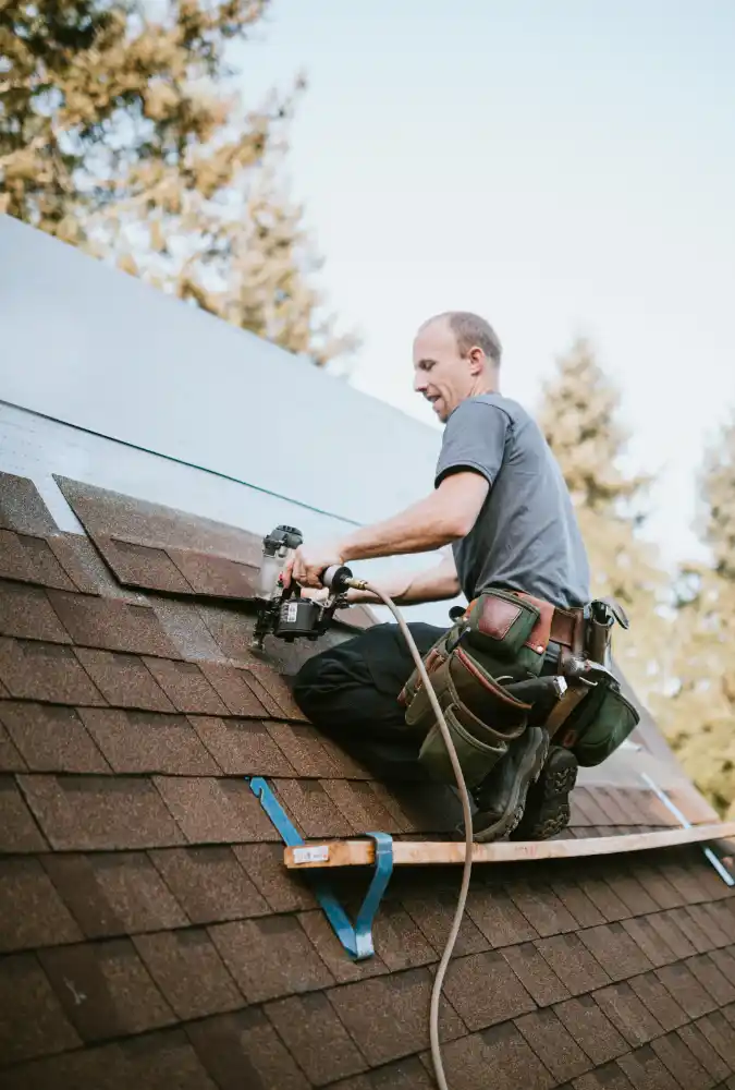 Shingles being nailed by roofer